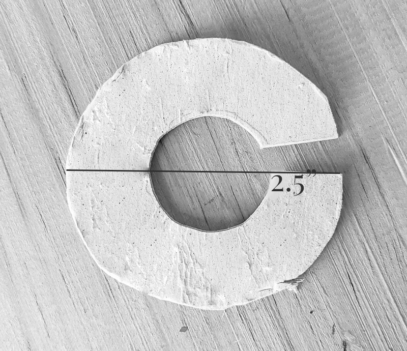 Cardboard cut in a \'c\' shape to make a pompom.