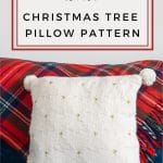 White Knit pillow against a red plaid blanket.