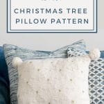White Christmas Tree Pillow on blue sofa with other pillows in the background.