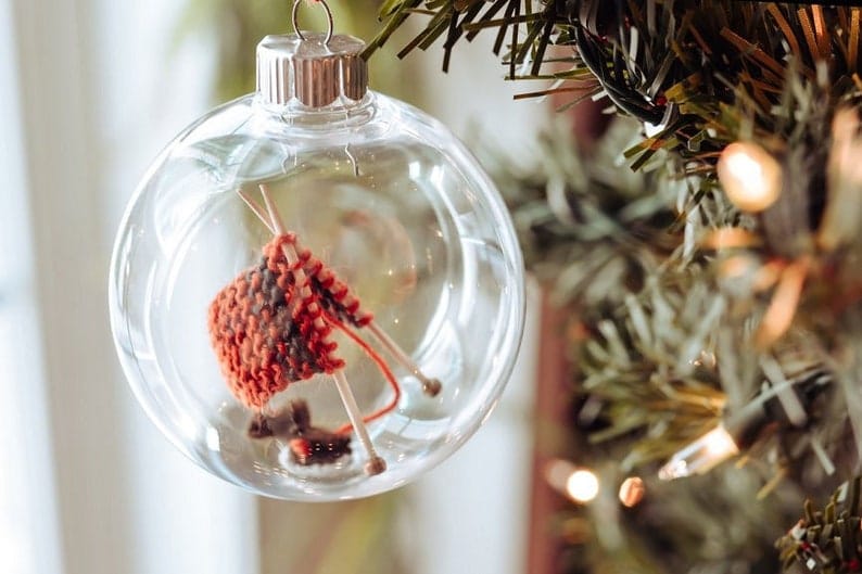 Small knitting sample inside of a glass ornament.