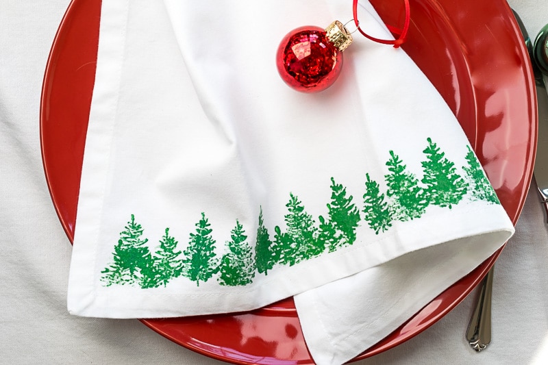 Stamped Fabric Christmas Tree Napkins on a red plate.