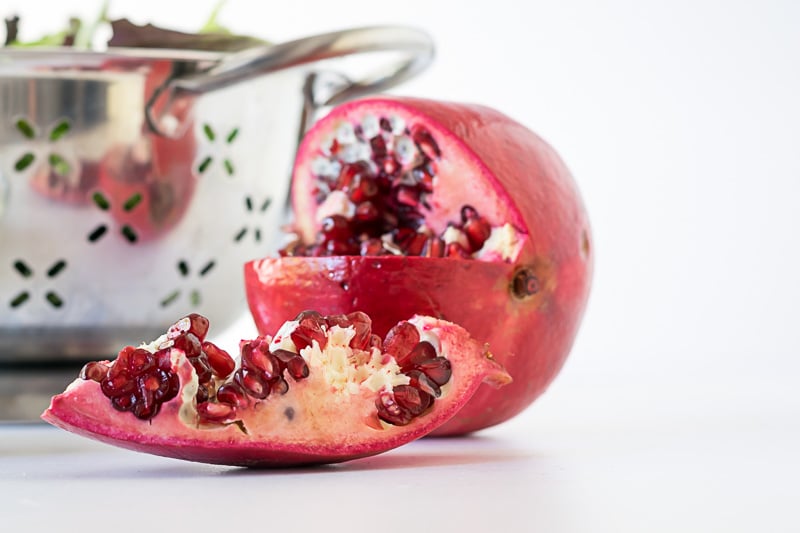 A pomegranate, with a quarter sliced out.