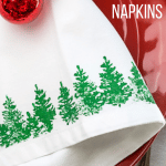 Stamped Fabric Napkin with Christmas Trees on a red plate.