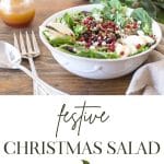Image of Christmas Salad in a white bowl with a pomegranate, a jar of dressing and greens in the background.