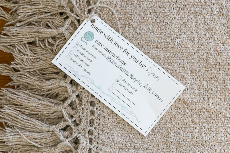 Knit blanket with knit care tag tied on.