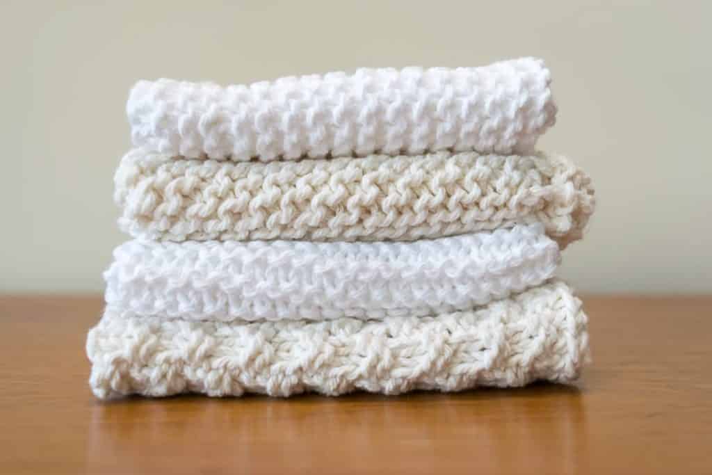 A stack of dishcloths in beige and white.