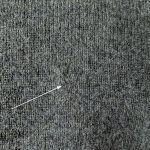 Mended hole in a gray sweater.