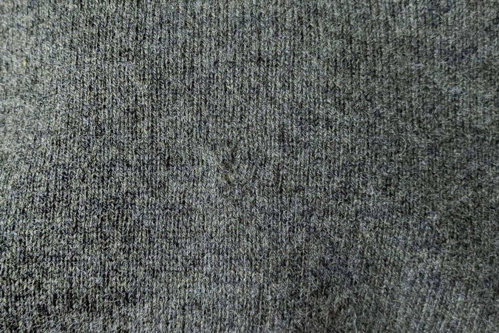 Mended hole in a gray sweater.