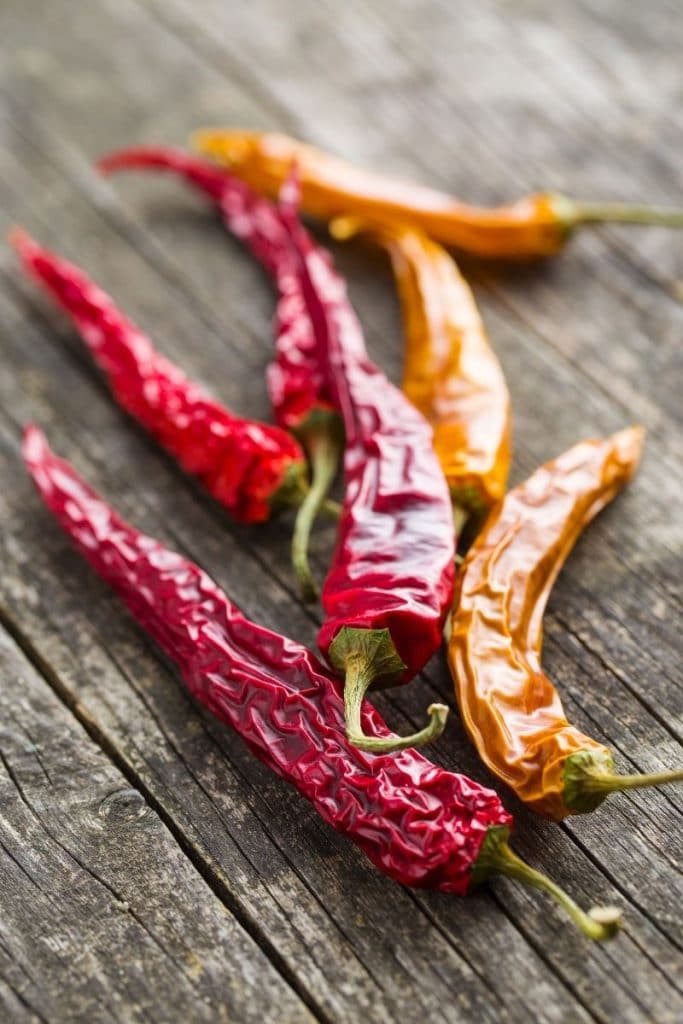 A close up of red and yellow dried chili peppers.
