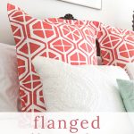 Coral and White Pillow Shams on Bed.