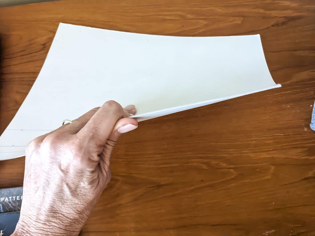 Piece of cardboard held in a hand.