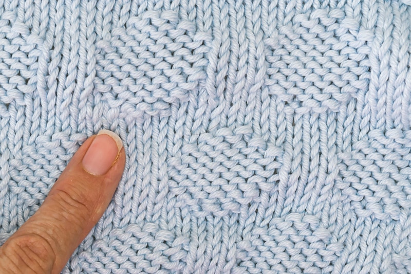 closeup of polka dots on blue baby blanket.