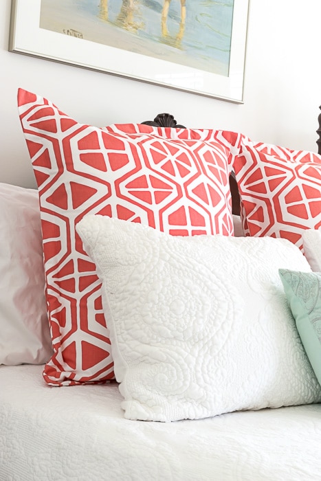 Orange and white pillows on a bed.