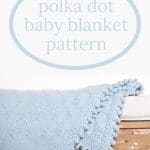 Blue Knit Polka Dot Baby Blanket on Wooden Bench.