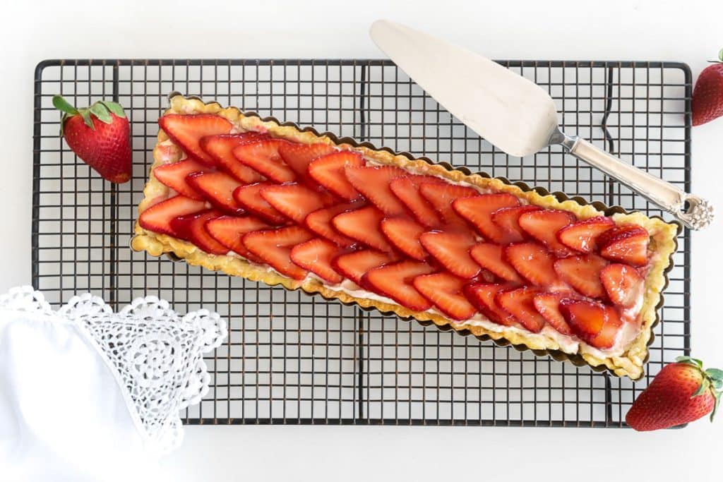 Strawberry tart on cooling rack.