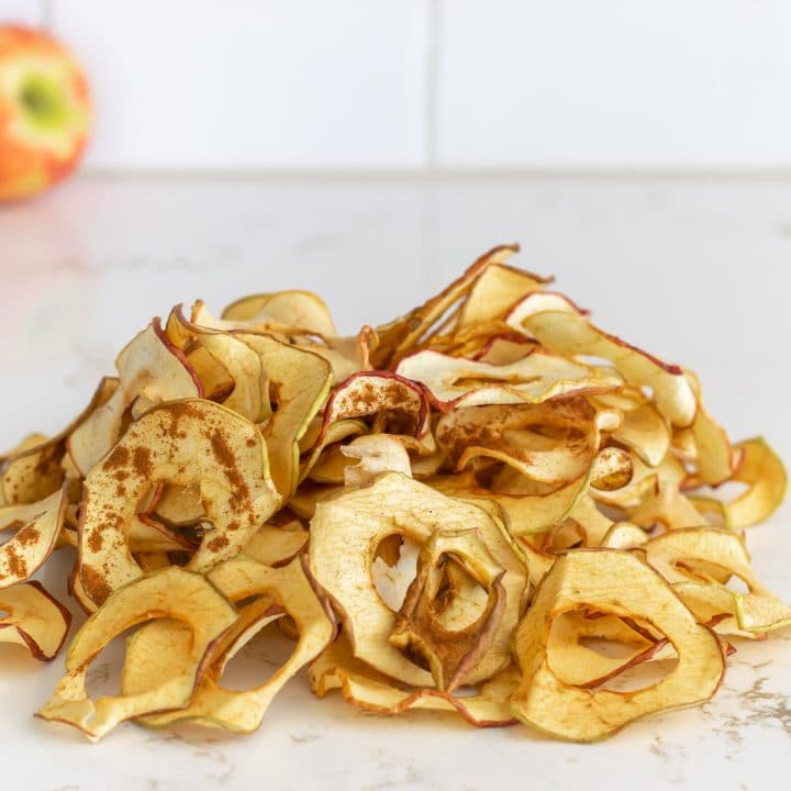A nice pile on the counter of dehydrated apple slices.