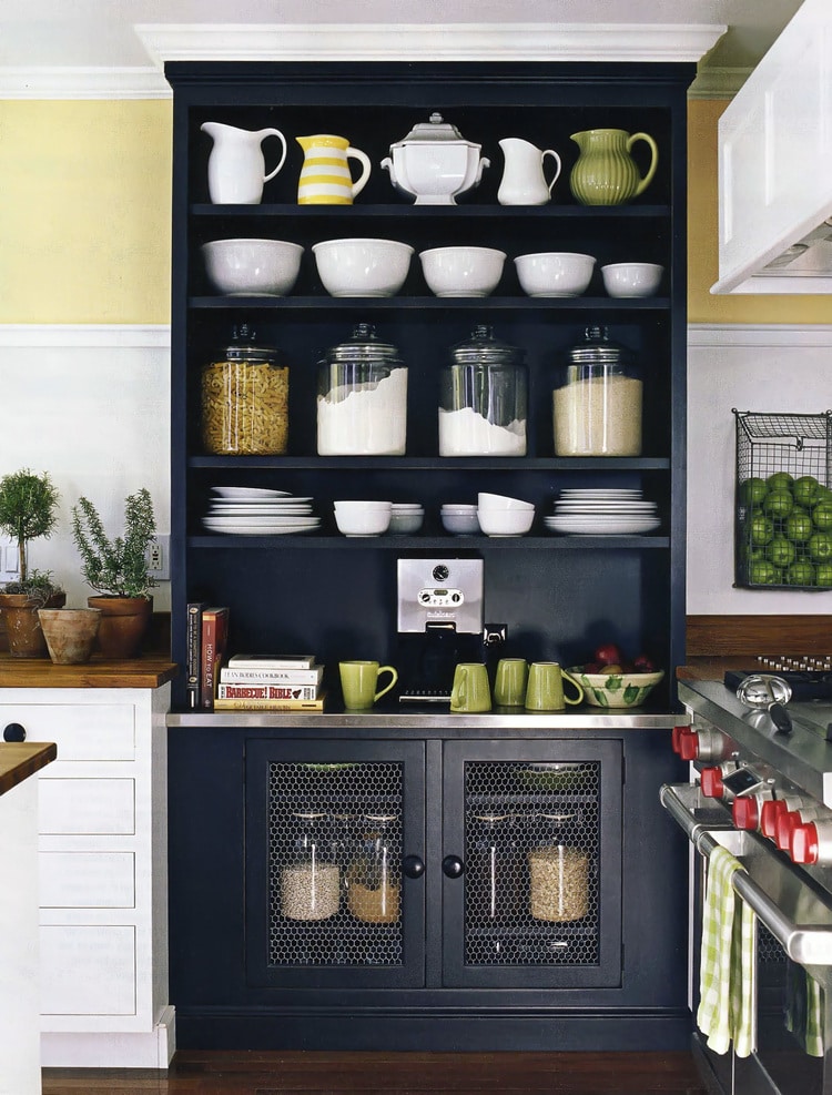 Dark blue Cupboard with bowls, pitchers and food storage jars.