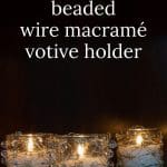 Three beaded wire macramé votive holders with lit candles in the dark.