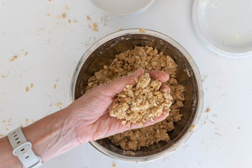 Hand holding streusel topping.