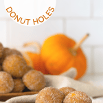 Three pumpkin spice donut holes on a wooden plate.