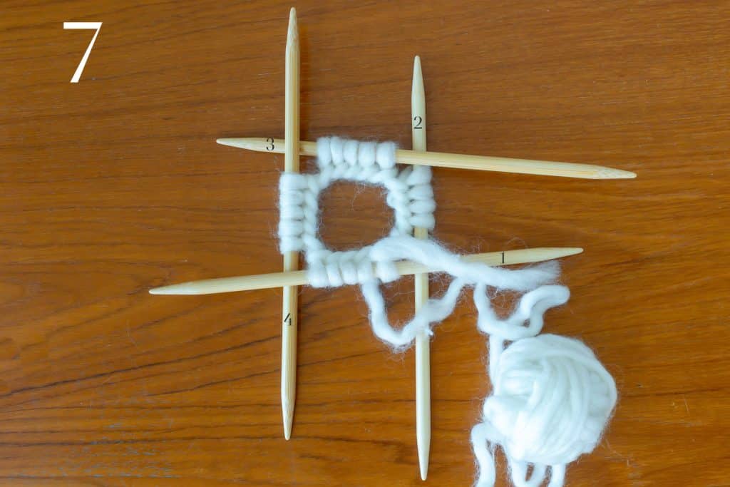 All stitches on four double-pointed needles, with cast on edge on the inside and not twisted.
