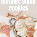 Painted Metallic Sugar Cookies on a beige tablecloth and silver tray.