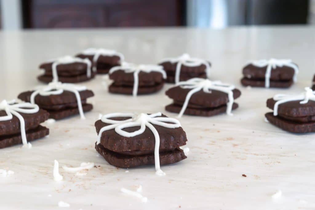 Chocolate Sandwich cookies with icing that looks like a ribbon.