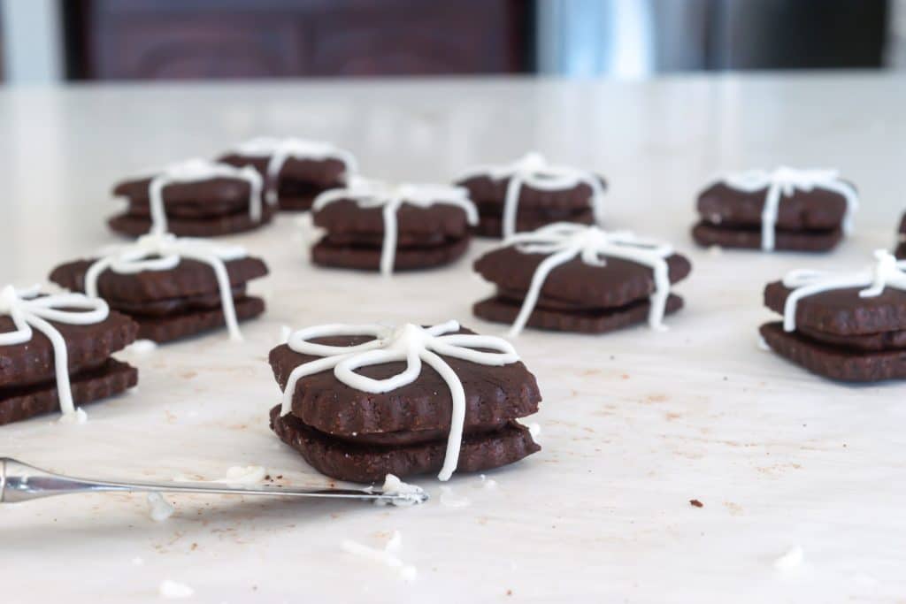 Chocolate sandwich cookies with icing that looks like ribbon.