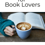 Hand holding coffee with open book.
