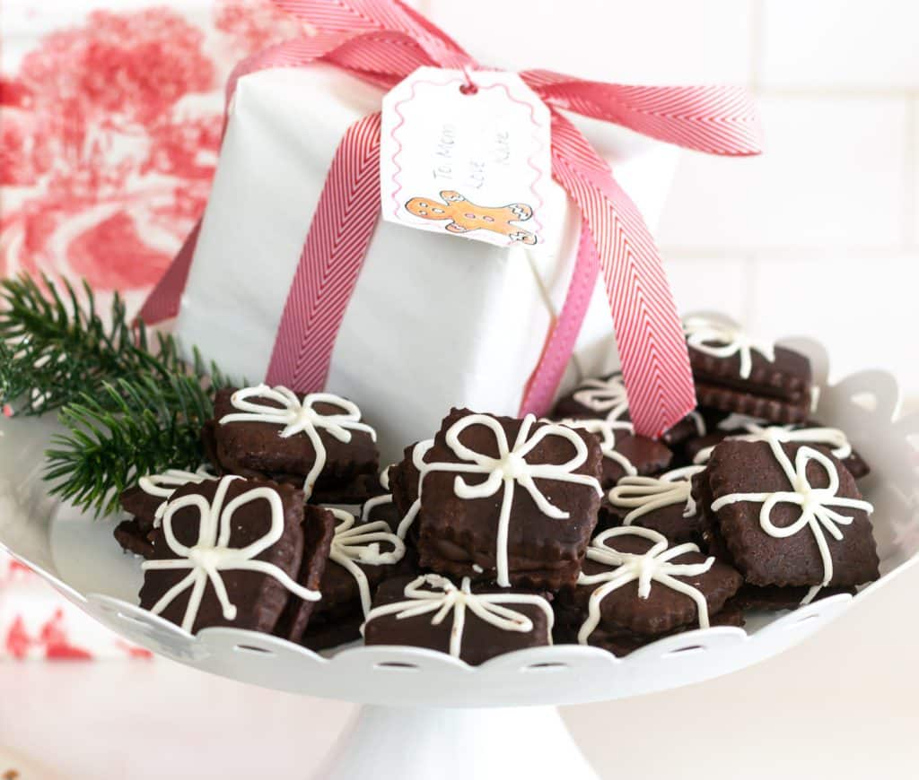 Chocolate Sugar Cookie 'presents' on a tray with a wrapped present in the background.
