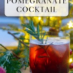 Spiced Pomegranate Cocktail in front of a lit Christmas tree.