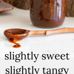 Jar of homemade barbecue sauce with a wooden spoon.