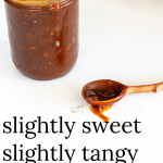 Jar of homemade barbecue sauce with a wooden spoon.