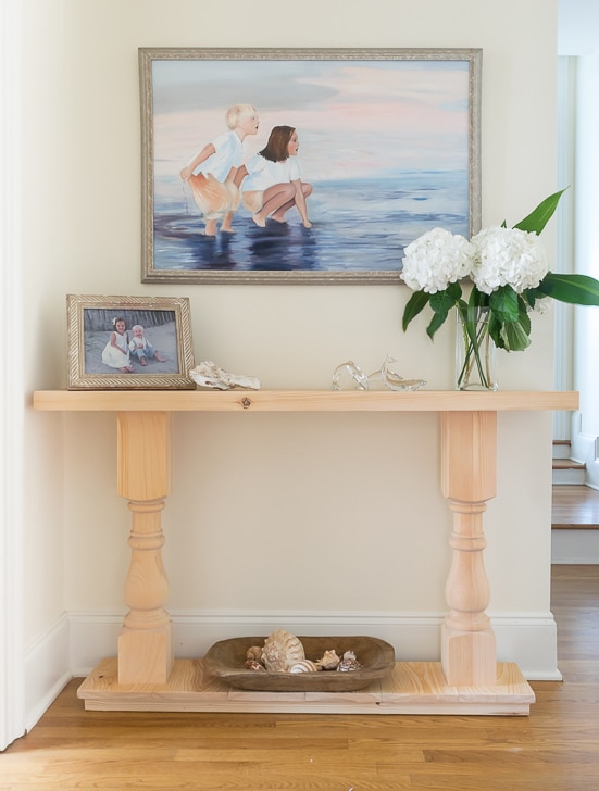 Console table with painting above it.