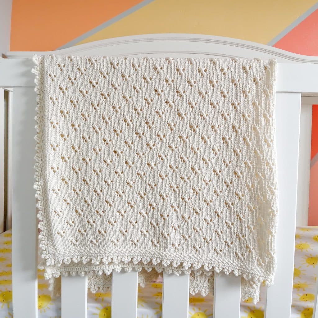 Knit baby blanket on crib