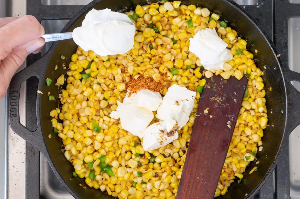 Add sour cream and cream cheese to corn in the skillet.