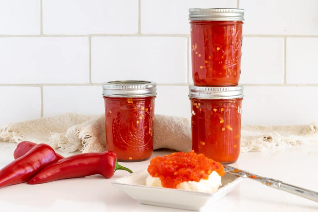 jars of red pepper jelly and red pepper jelly over cream cheese.