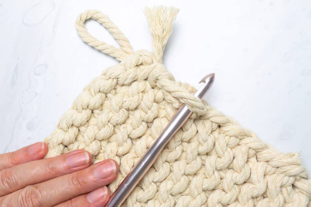 Crochet hook with knit garter trivet.
