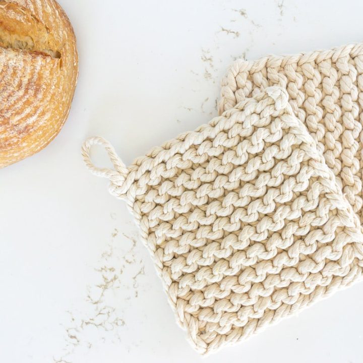 Two garter stitch trivets with a loaf of bread
