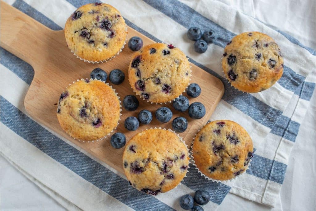 blueberry muffins on cutting board.
