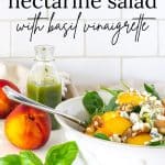 Spinach and Nectarine Salad in a white bowl with nectarines, basil and basil vinaigrette in the background.