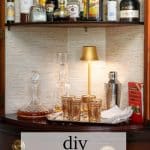 Finished DIY Bar Cabinet with lamp and barware.