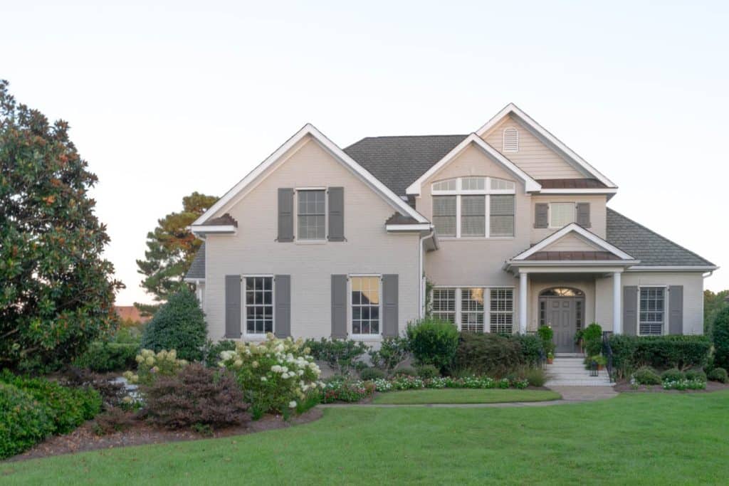 Brick home painted with Revere Pewter and Kendall Charcoal on the shutters.