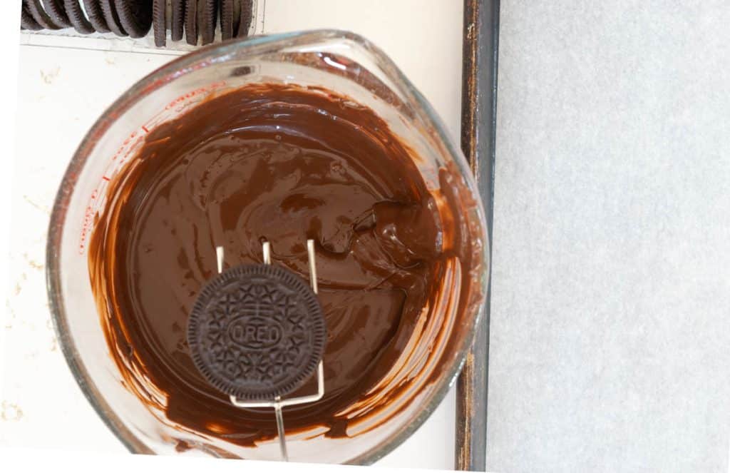 Dipping oreo in chocolate.