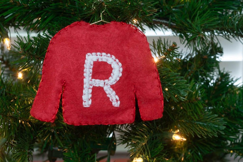 Letter R on red felt sweater.