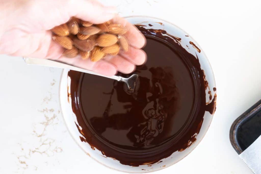 Add almonds to melted chocolate.