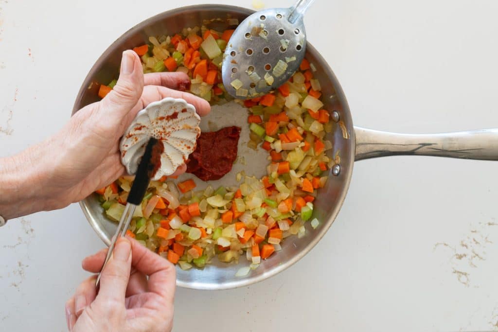 Add tomato paste to skillet.