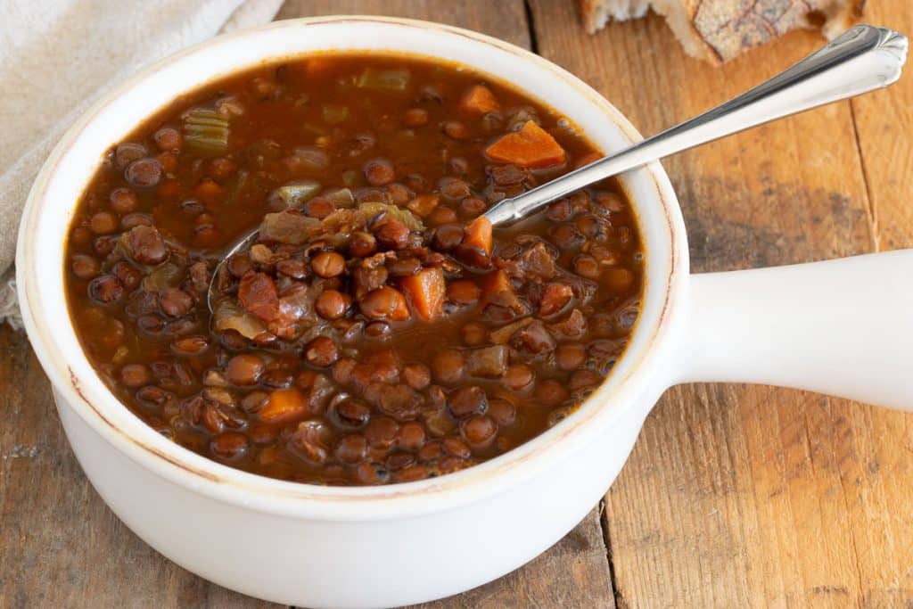 Overhead of lentil soup in white bowl.