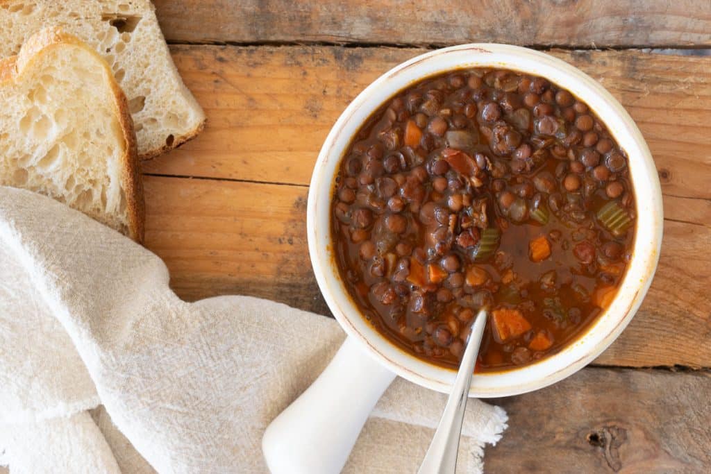 Overhead of lentil soup in white bowl.