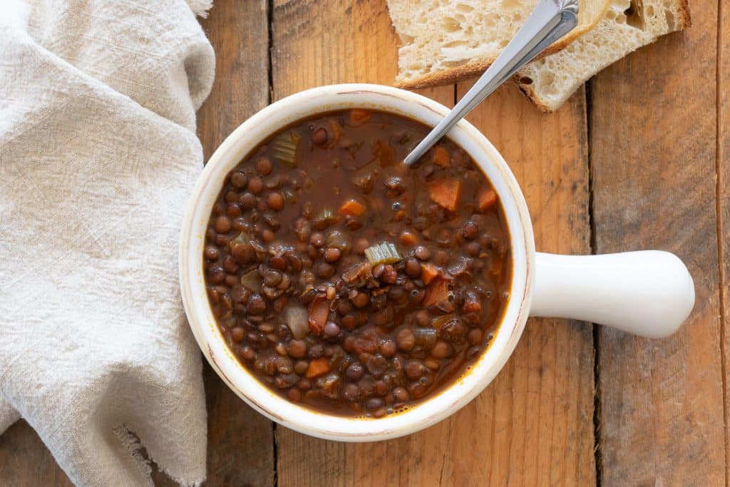 Overhead of lentil soup in white bowl.